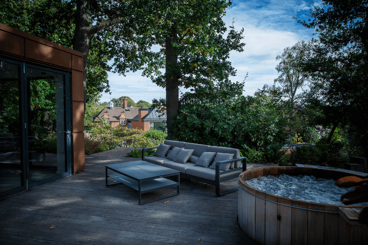 A deck with seating and a hot tub